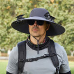 Outdoor hat with solar panel powering dual cooling fans